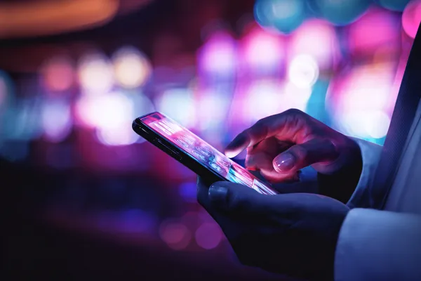 A woman smiling by bright slot machines showing lucky symbols, showcasing the exciting slot offerings at BD111.